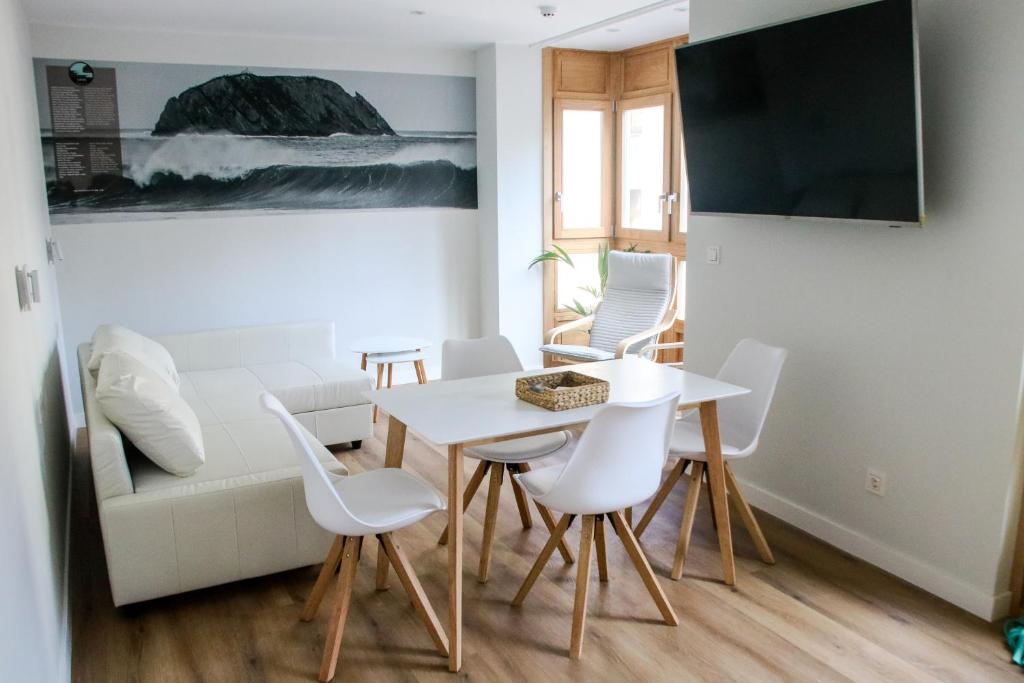 A television and/or entertainment centre at Apartamentos Mundaka Surf Camp