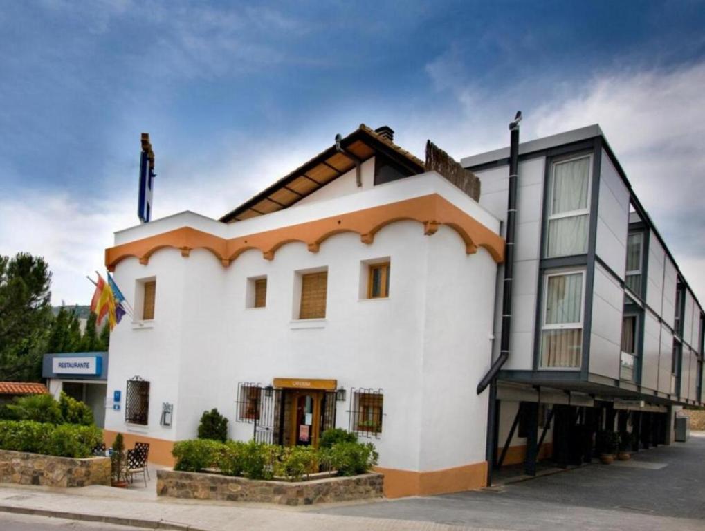 a white building with a black and orange roof at Hotel De Jerica in Jérica