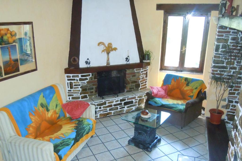 sala de estar con 2 sillas y chimenea en Casa Romantica in Liguria, en Testico