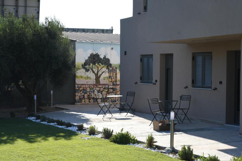 a patio with chairs and a table in front of a house at Orion Eco Suites in Karteros