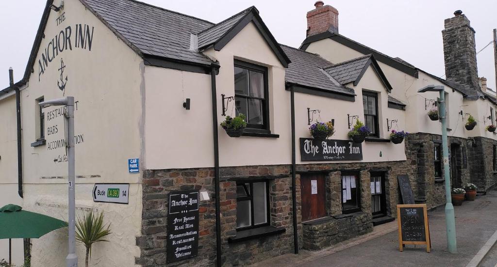 een wit gebouw met bloemen op de ramen bij The Anchor Inn in Hartland