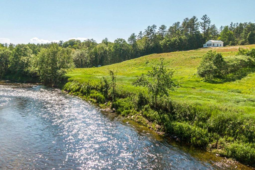 a river with a house in the middle of a field at Cozy Bethel Escape with Views Less Than 10 Mi to Ski! in Bethel
