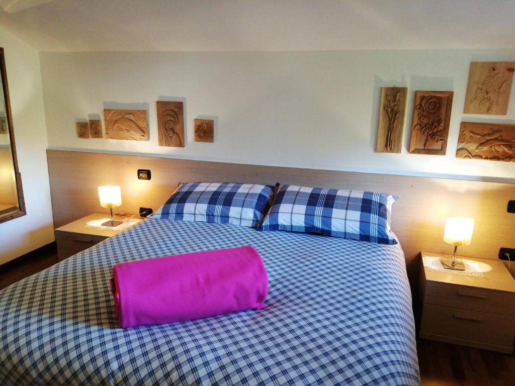 a bedroom with a large bed with a pink pillow on it at B&B Carunei in Poggiridenti