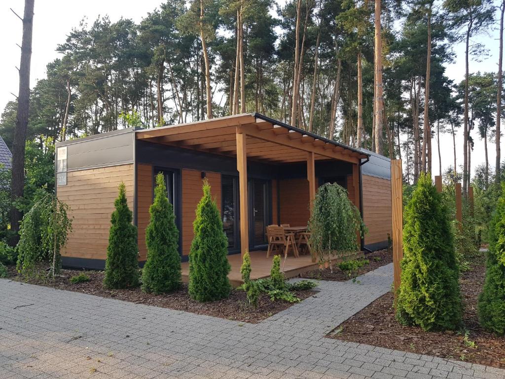 a small cabin with a table in a garden at JH2 domek M&M Apartments in Altanka