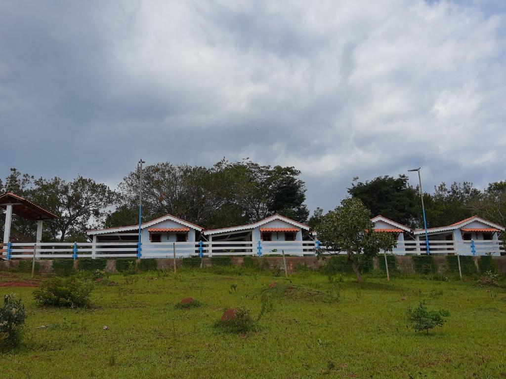 a row of houses with a fence in a field at Chalés do Apolinário in Tiradentes