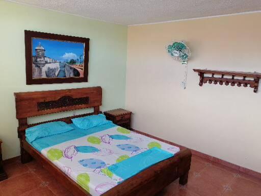 1 dormitorio con 1 cama con una pintura en la pared en HOTEL TAYRONA IMPERIAL en Bucaramanga