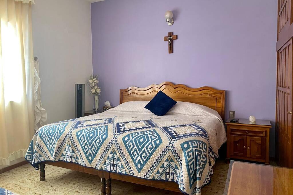 a bedroom with a bed with a blue and white quilt at Casa Marquita en el centro de Talpa de Allende. in Talpa de Allende