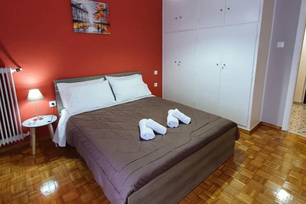 um quarto com uma cama com dois chinelos brancos em Greek hospitality in a modern apartment em Atenas
