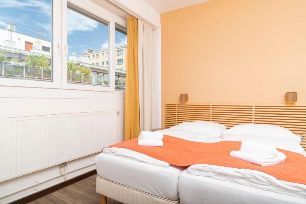 1 dormitorio con 2 camas y ventana grande en Apartments Favoriten, en Viena