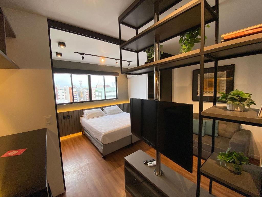 ein Schlafzimmer mit einem Bett und einem TV in einem Zimmer in der Unterkunft Edifício Time Apto 1121 ER Hospedagens in Maceió
