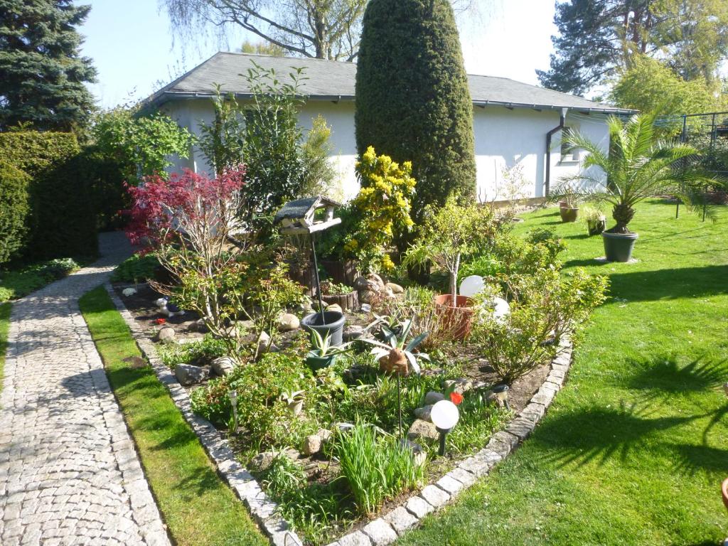 a garden in front of a house with plants at Ferienhaus Görsdorf Berlin in Berlin