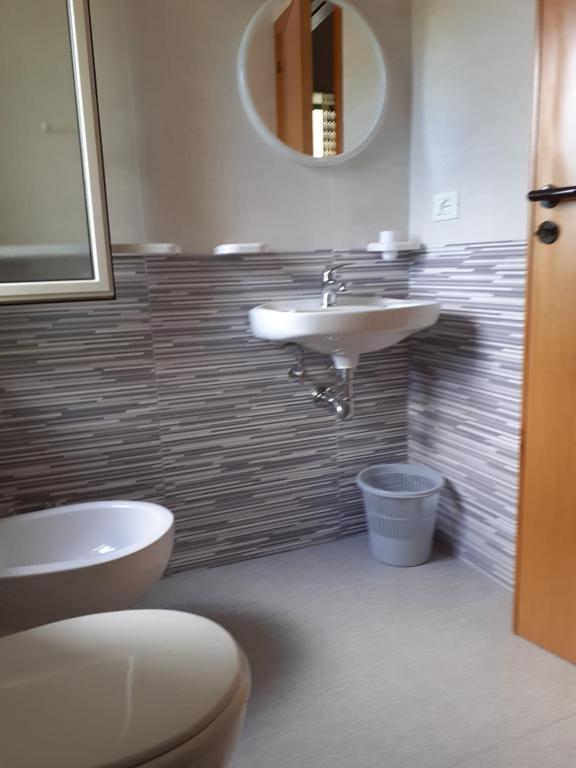 a bathroom with a sink and a toilet and a mirror at La Marina Bay in Vieste