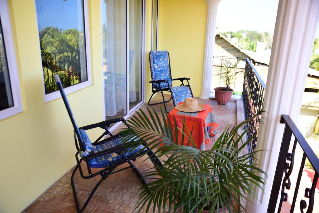two blue chairs and a table on a porch at Casa Rosa in Flic-en-Flac