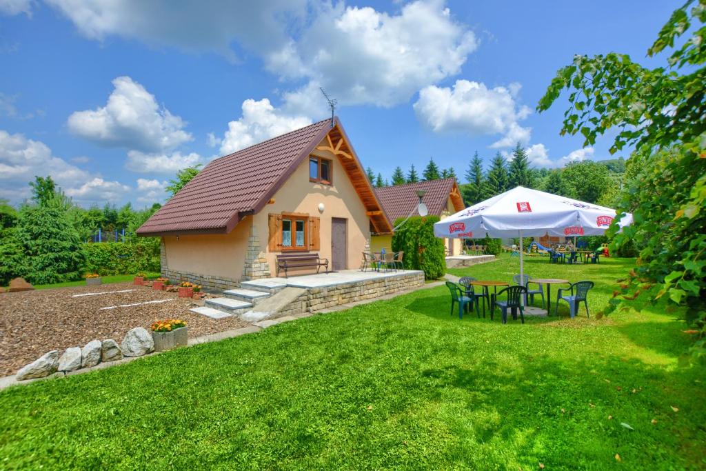 un cottage avec une table et des chaises dans la cour dans l'établissement Domki nad Stebnikiem, à Ustrzyki Dolne