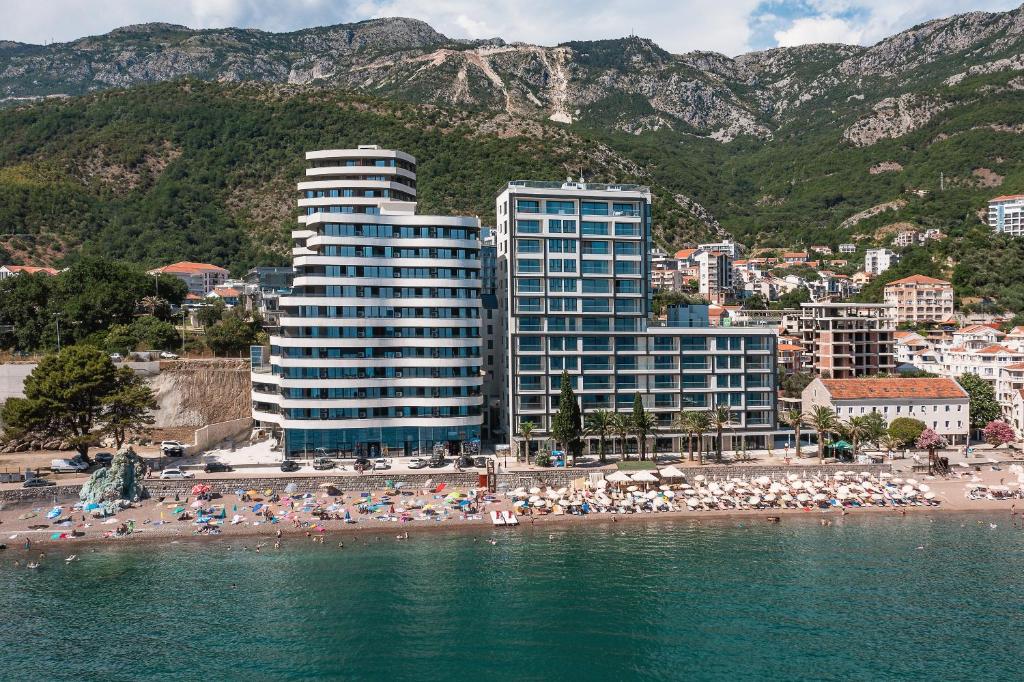 ein Strand mit einigen Gebäuden und Menschen am Strand in der Unterkunft Green Stone Apartments Hotel in Rafailovici