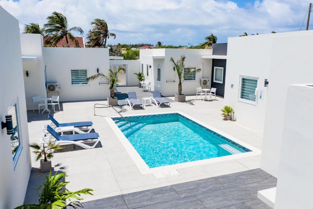 a villa with a swimming pool and a patio at The Palm Leaf Apartments in Noord