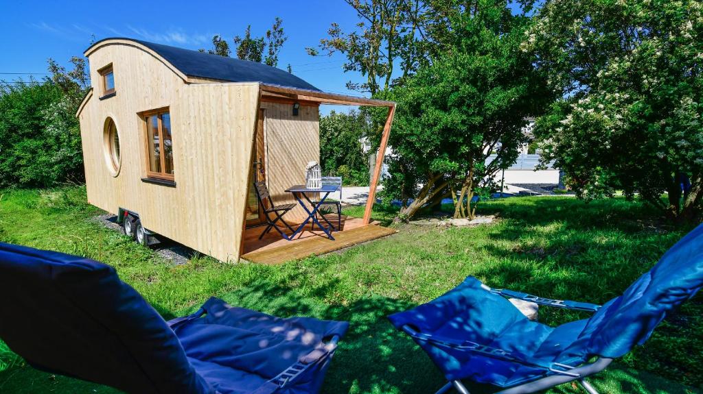 een tiny house met een tafel en stoelen in het gras bij Tiny Côte d’Opale in Audresselles