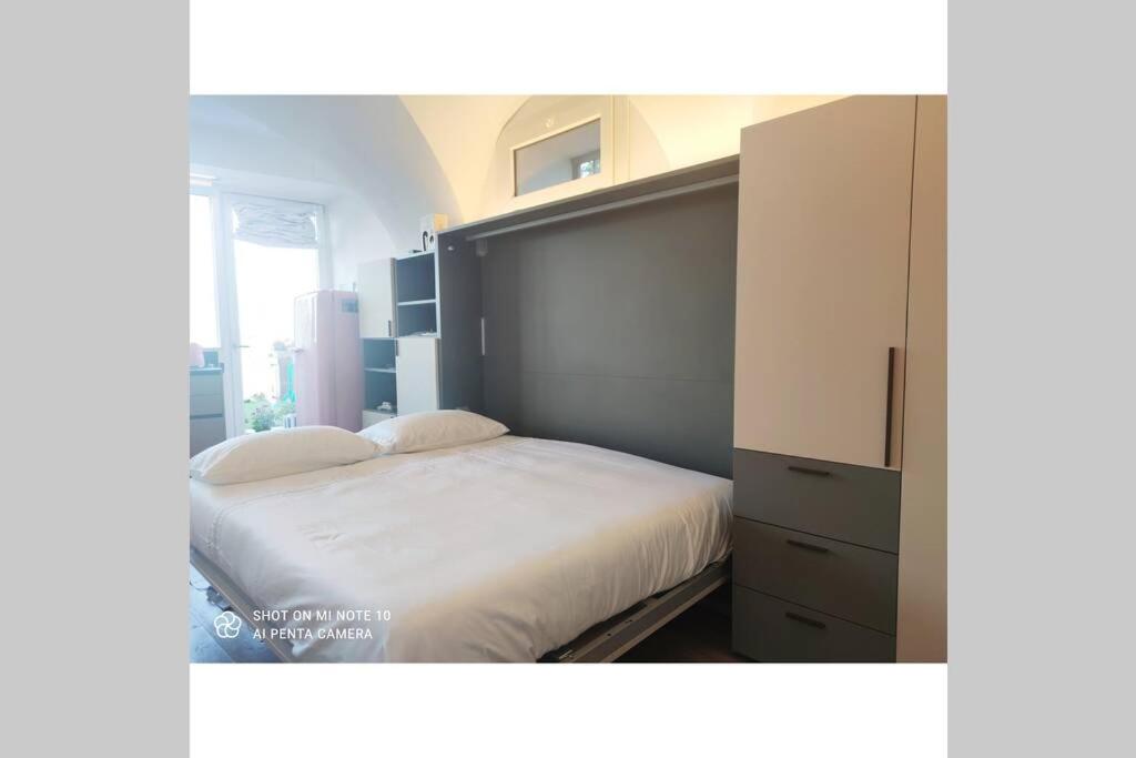 1 dormitorio con 1 cama blanca grande y vestidor en Gioiello sul lago d'Iseo, en Sale Marasino
