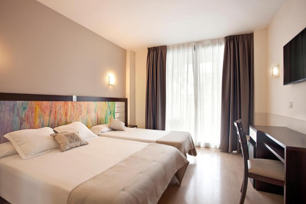 A bed or beds in a room at Hotel Indalo Park