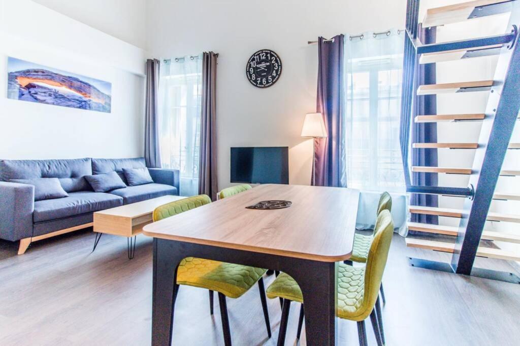 - un salon avec une table, des chaises et un canapé dans l'établissement APPARTEMENT HAUSSMANNIEN TYPE LOFT, CLIMATISE - VIEUX-PORT-LE PANIER,, à Marseille