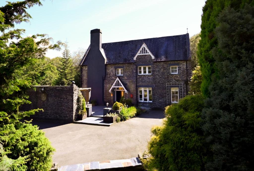 a large brick house with a large driveway at The Old Vicarage B&B, Corris in Machynlleth