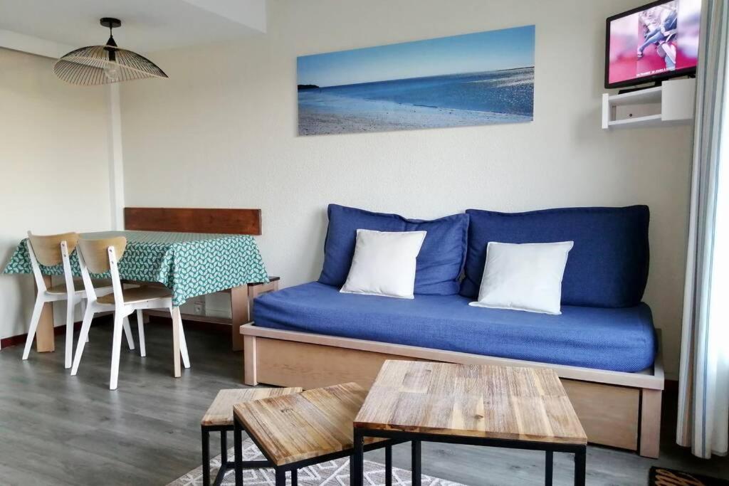 a living room with a blue couch and a table at Appartement 4 personnes Arzon, entre plage et Port Crouesty in Arzon