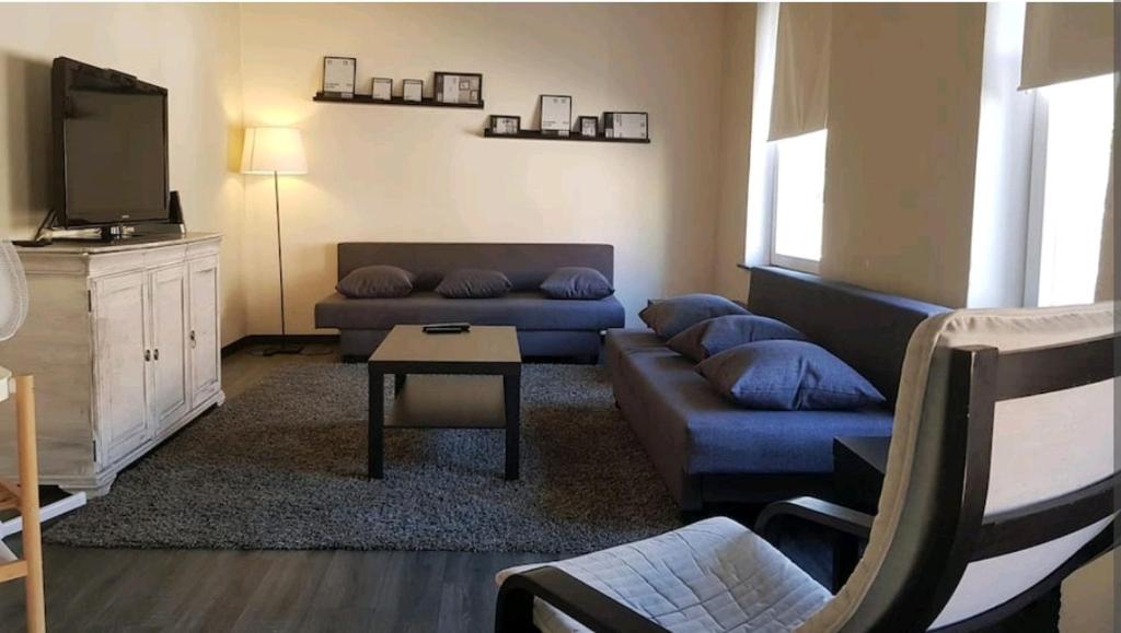 sala de estar con sofá y TV en Charmante maison lumineuse au coeur de Liège!, en Ans