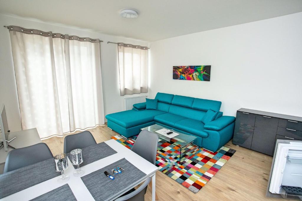a living room with a blue couch and a table at Blue apartment Klínovec in Loučná pod Klínovcem
