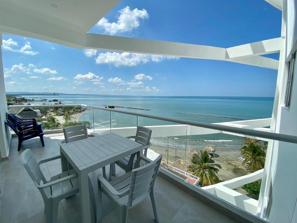 balcón con mesa, sillas y vistas al océano en Magico Apartamento Frente al Mar 3 Habitaciones FB73, en Coveñas