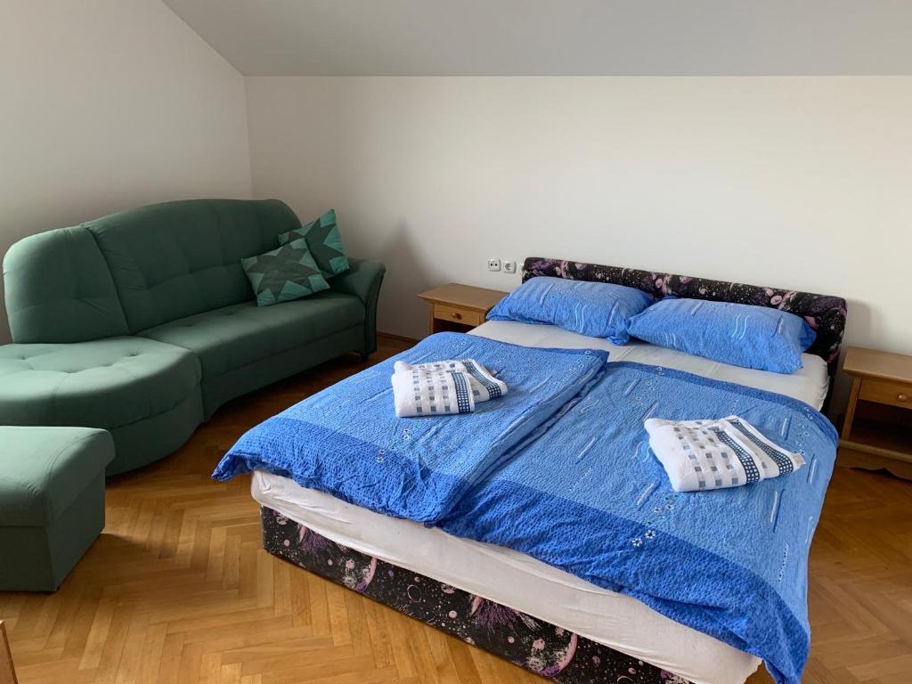 een slaapkamer met een bed en een bank bij Wine House, Zidanica Gruden in Novo Mesto