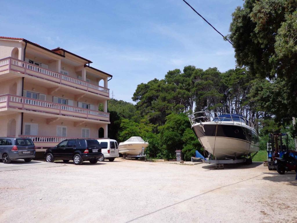 a boat is parked in front of a building at Apartments in Mundanije/Insel Rab 30445 in Mundanije
