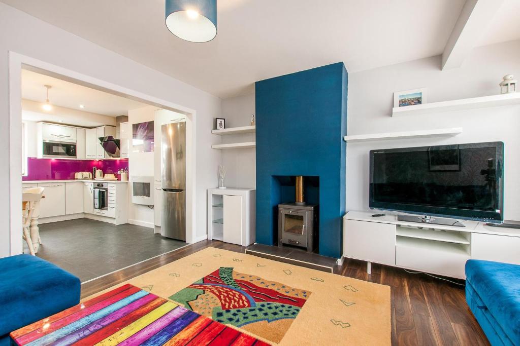 a living room with a blue wall and a tv at Green Acre View - Near Royal St Georges Golf Club in Sandwich