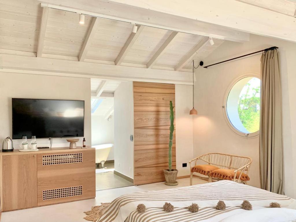 a bedroom with a large bed and a television at Santa Lucia Maccarese - Residenza Agricola in Maccarese