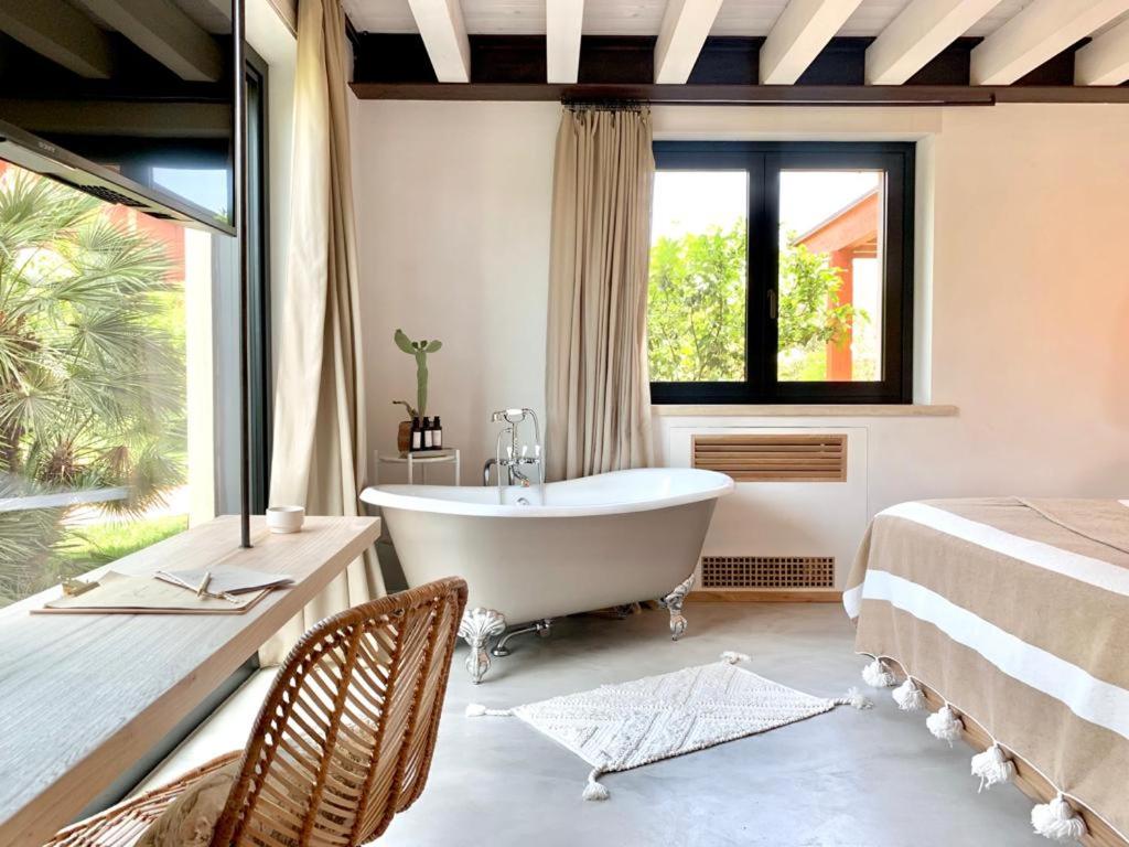 a bathroom with a tub and a bed and a window at Santa Lucia Maccarese - Residenza Agricola in Maccarese