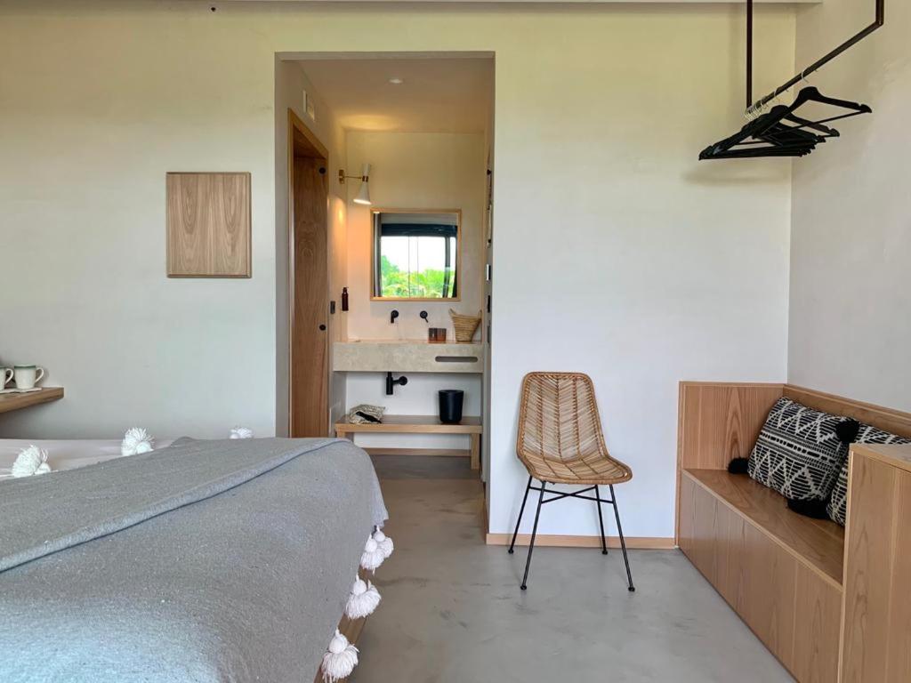 a bedroom with a bed and a chair in it at Santa Lucia Maccarese - Residenza Agricola in Maccarese