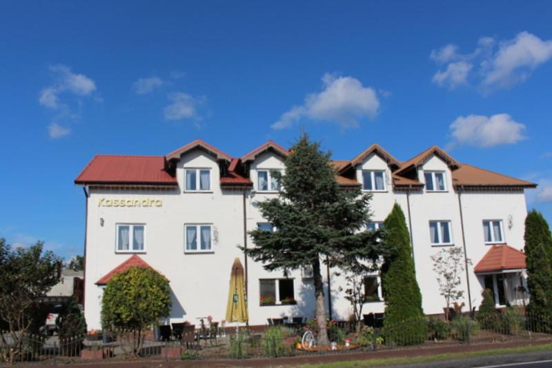 un gran edificio blanco con techo rojo en Restauracja Hotel Kassandra en Września