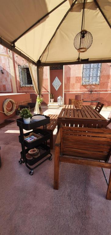 a patio with a table and a bench and an umbrella at Villa Rosa Boutique in Almancil