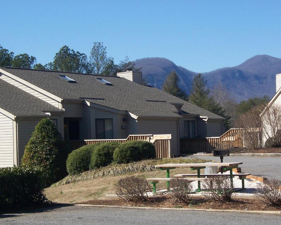 a house with a picnic table in front of it at Fairways of the Mountain, a VRI resort in Lake Lure