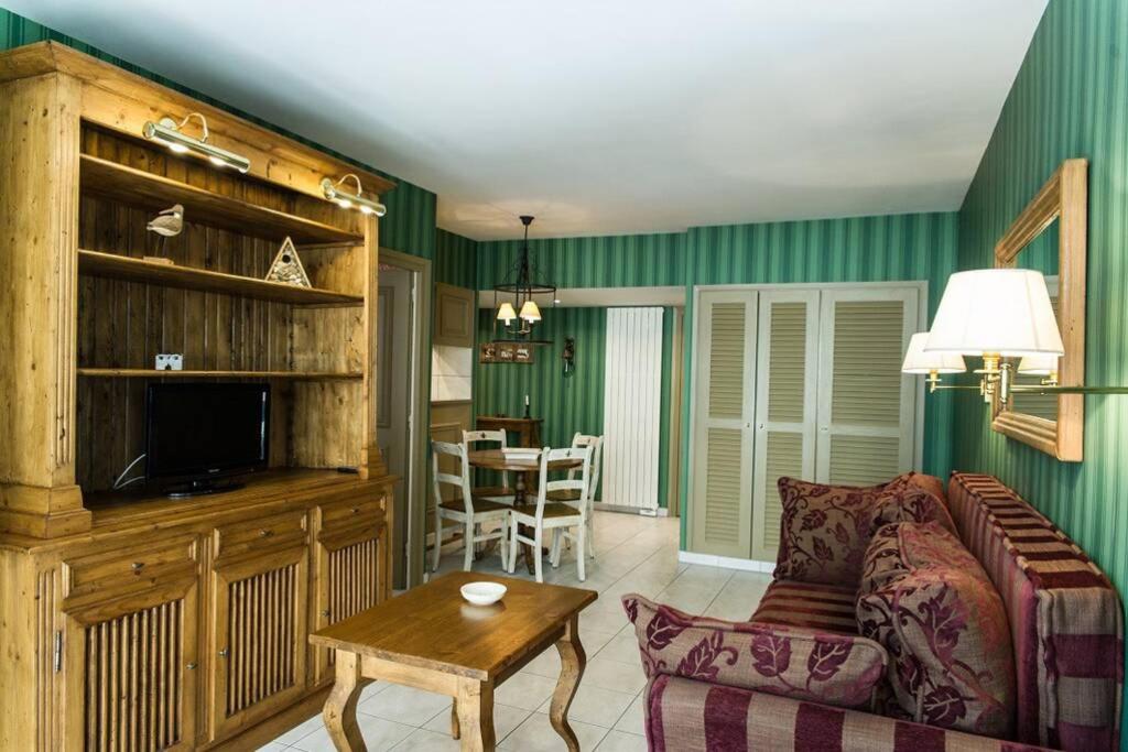 ein Wohnzimmer mit einem Sofa und einem Tisch in der Unterkunft Clos de Marie Appartement de Charme + Park Couvert in Font Romeu Odeillo Via