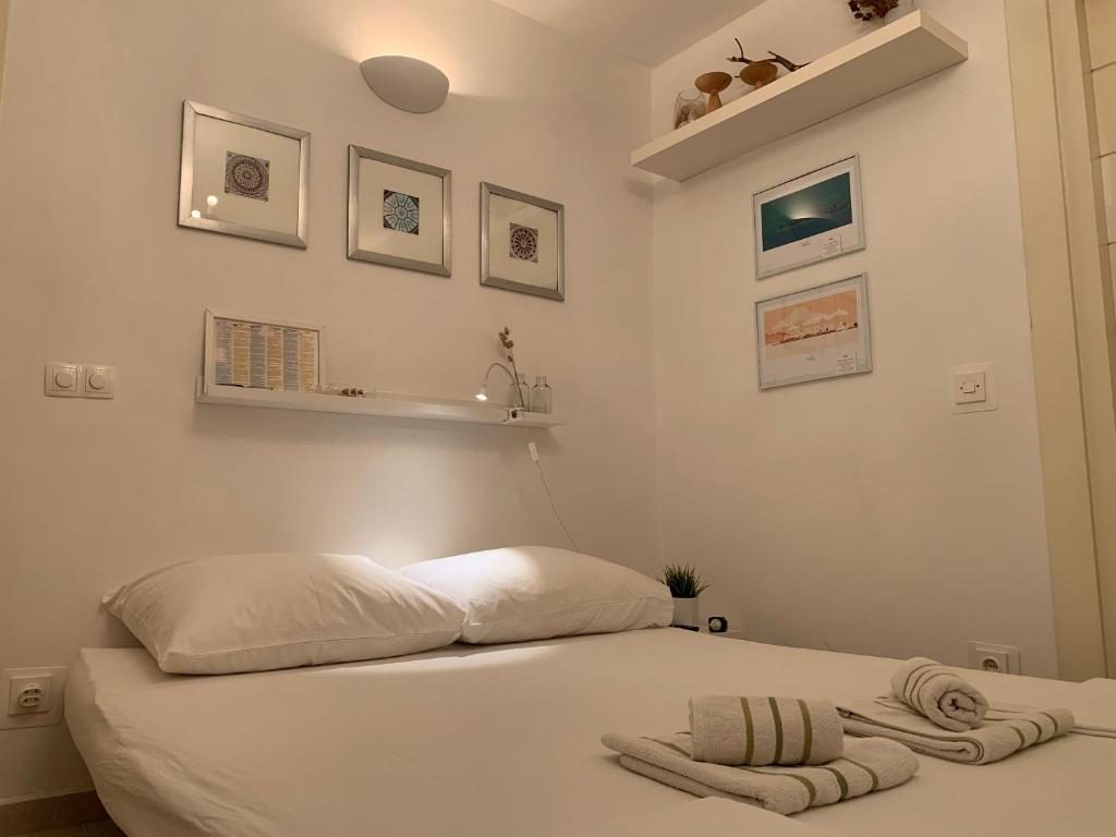 a bedroom with a white bed with towels on it at Guesthouse Villa Colenda in Korčula
