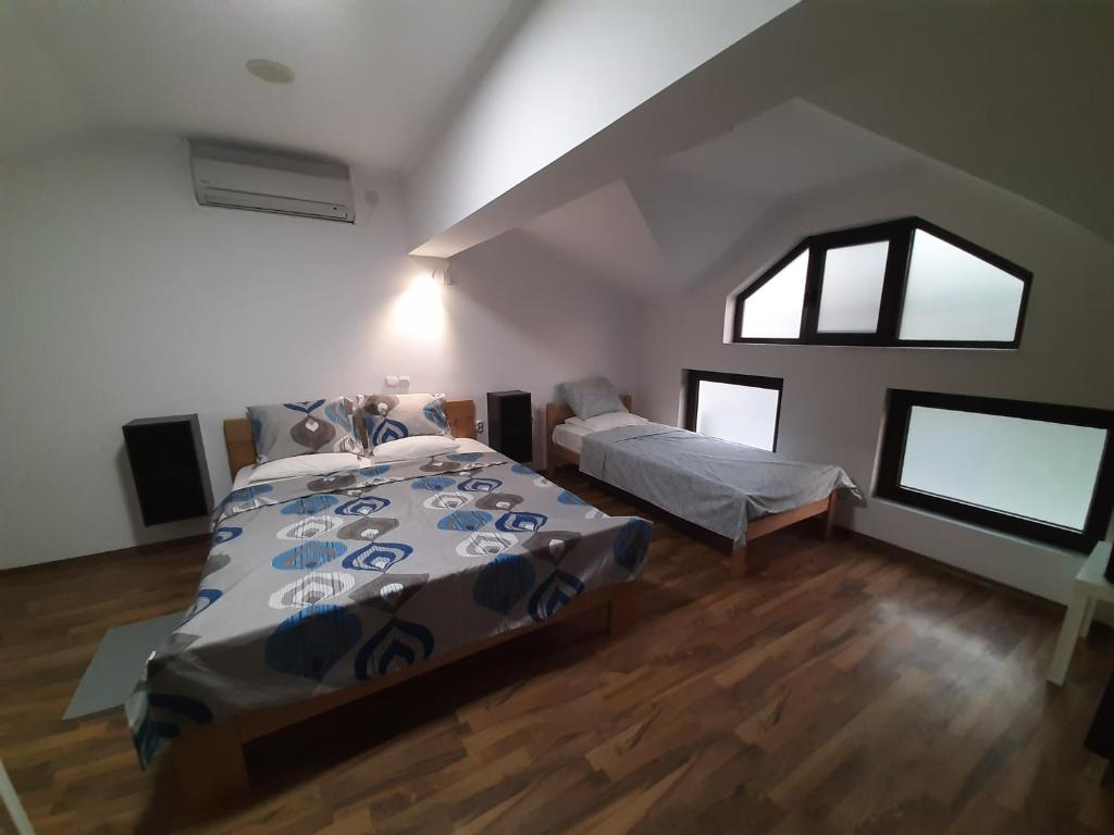 a bedroom with two beds and two windows at Fiori Apartment in Gevgelija