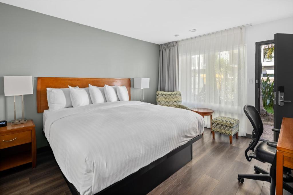a hotel room with a bed and a desk and chair at Vagabond Inn Glendale in Glendale