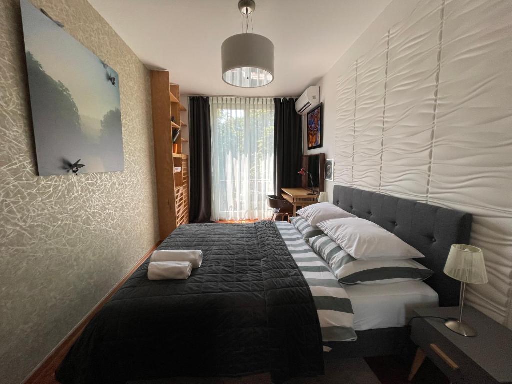 a bedroom with a black and white bed and a window at Apartament Koszykowa Latwiec in Warsaw