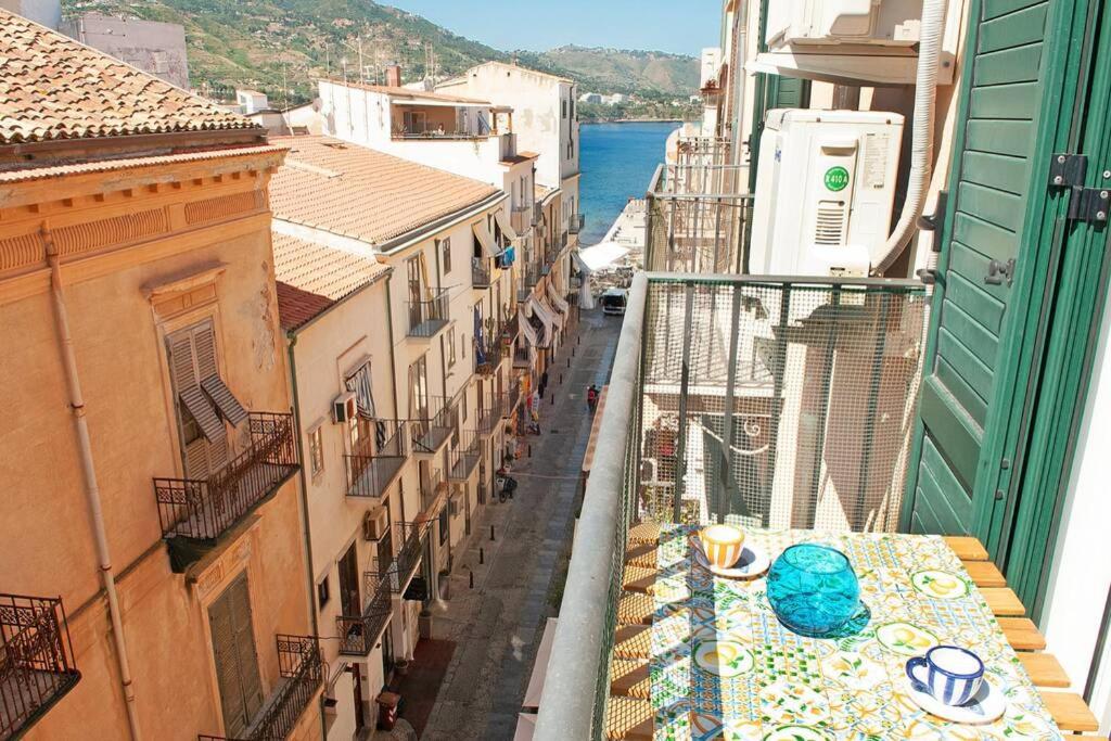 uitzicht op een straat met gebouwen en de oceaan bij Blue Sea House in Cefalù