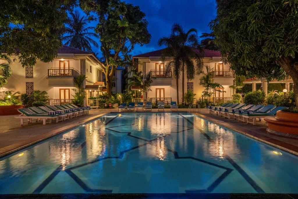 a swimming pool in front of a hotel at night at Radisson Goa Candolim in Candolim