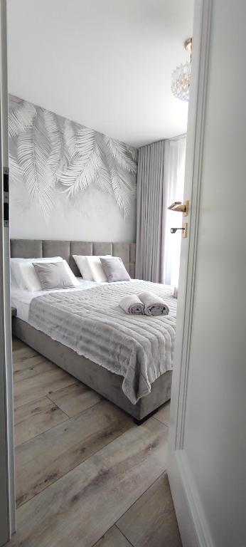 sypialnia z dużym łóżkiem i drewnianą podłogą w obiekcie Apartament Złote Noce w mieście Augustów