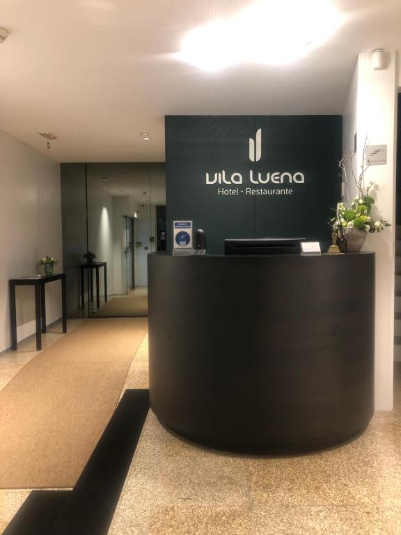 a lobby of a hotel with a sign on the wall at Hotel Vila Luena in Vila Verde