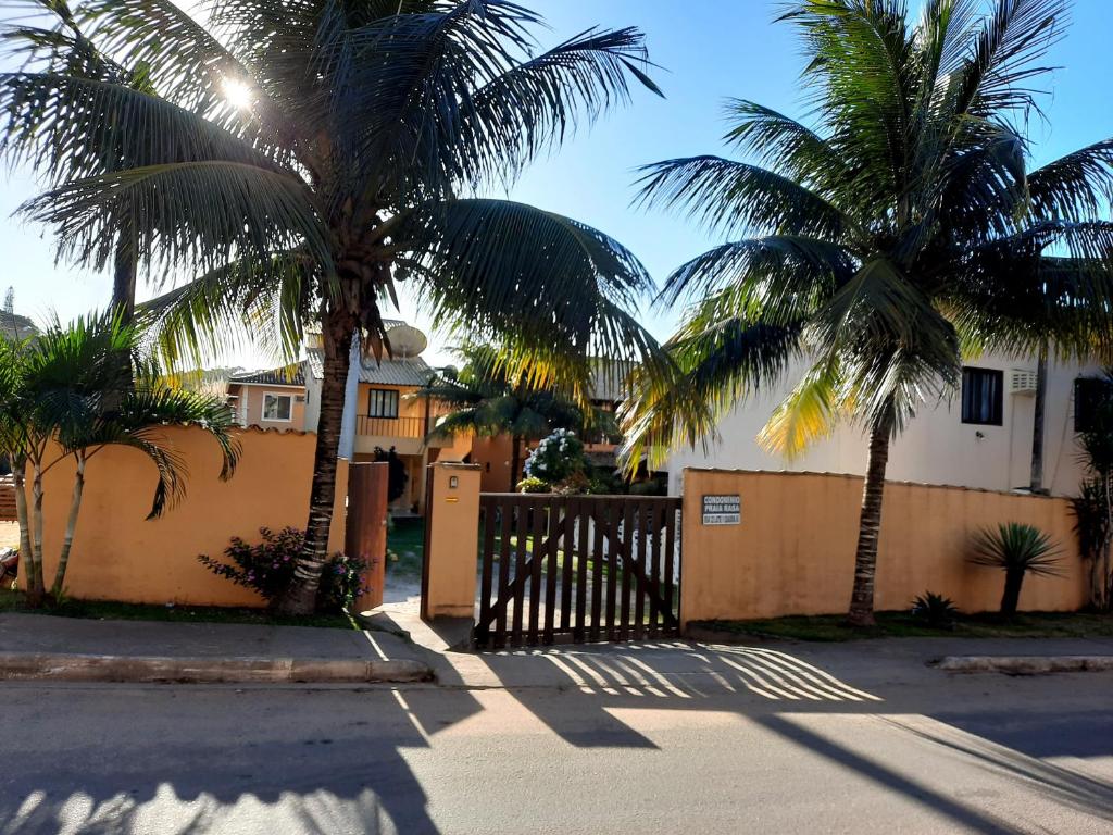 a gate to a house with two palm trees at Chale Buzios Praia Rasa in Búzios