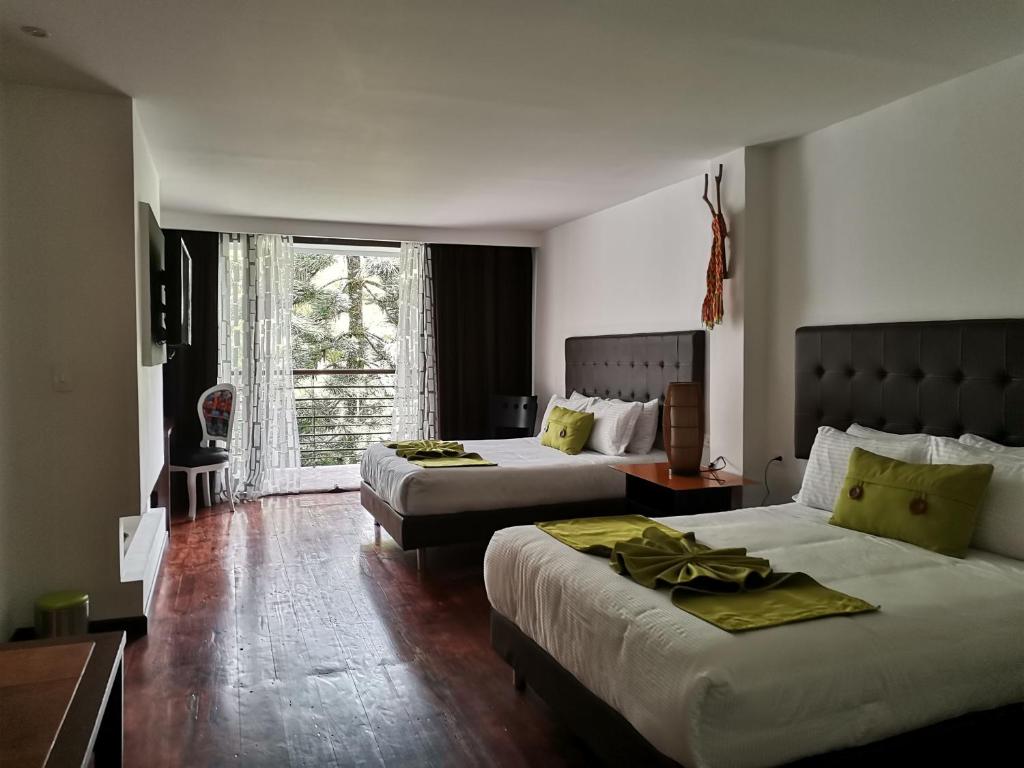 Cette chambre comprend 2 lits et une fenêtre. dans l'établissement Hotel Bambu Inn, à Salento