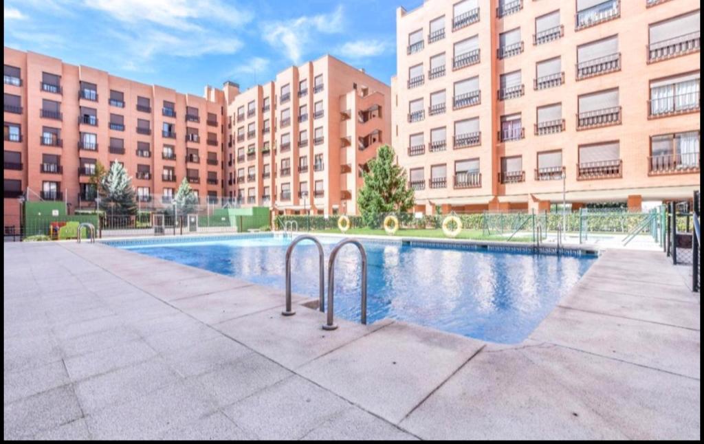 uma piscina em frente a um grande edifício em Apartamento 4 pax Airport Wanda Ifema WiFi em Madri